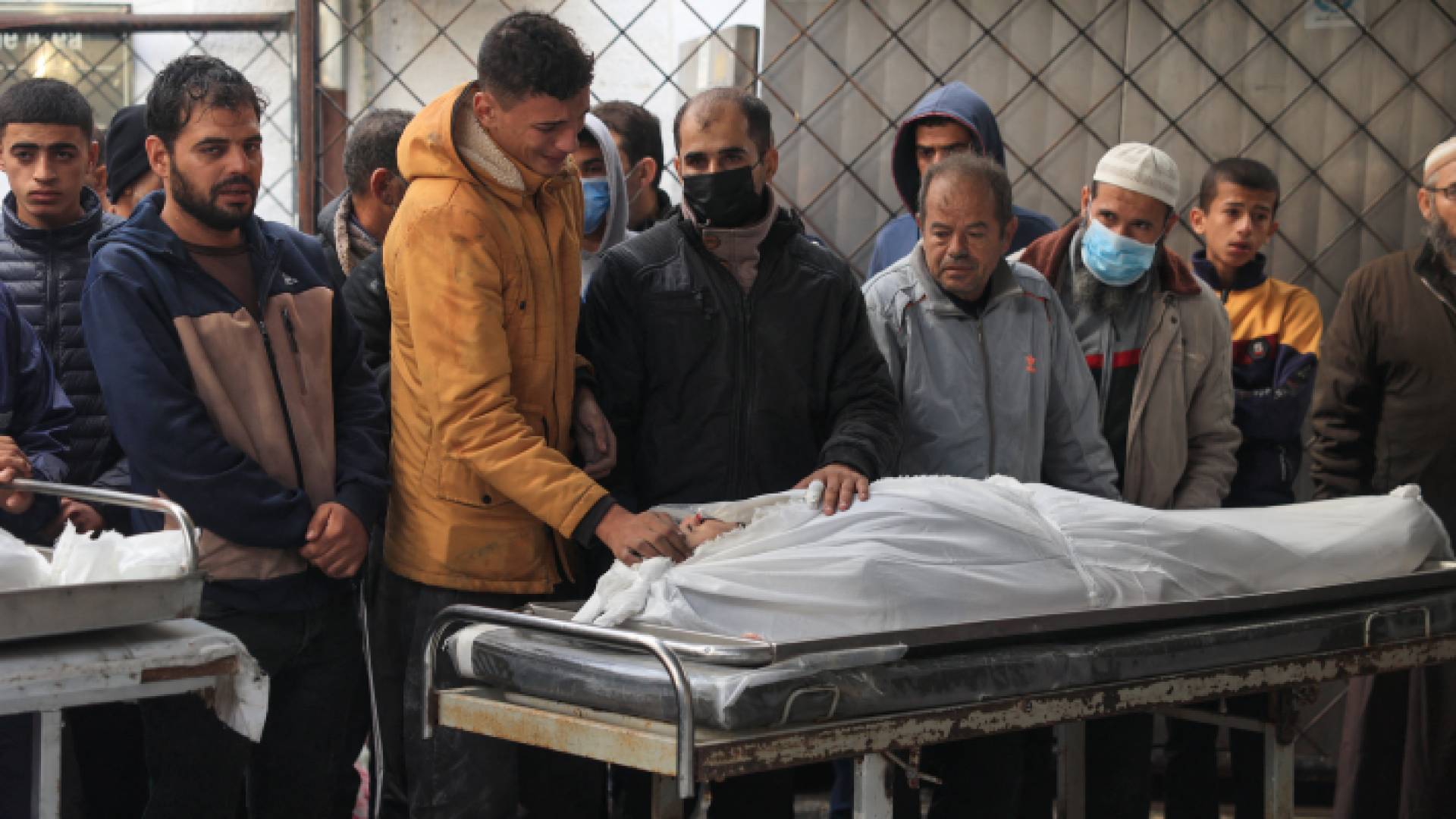 فلسطينيون يبكون بجانب شهيد في قطاع غزة