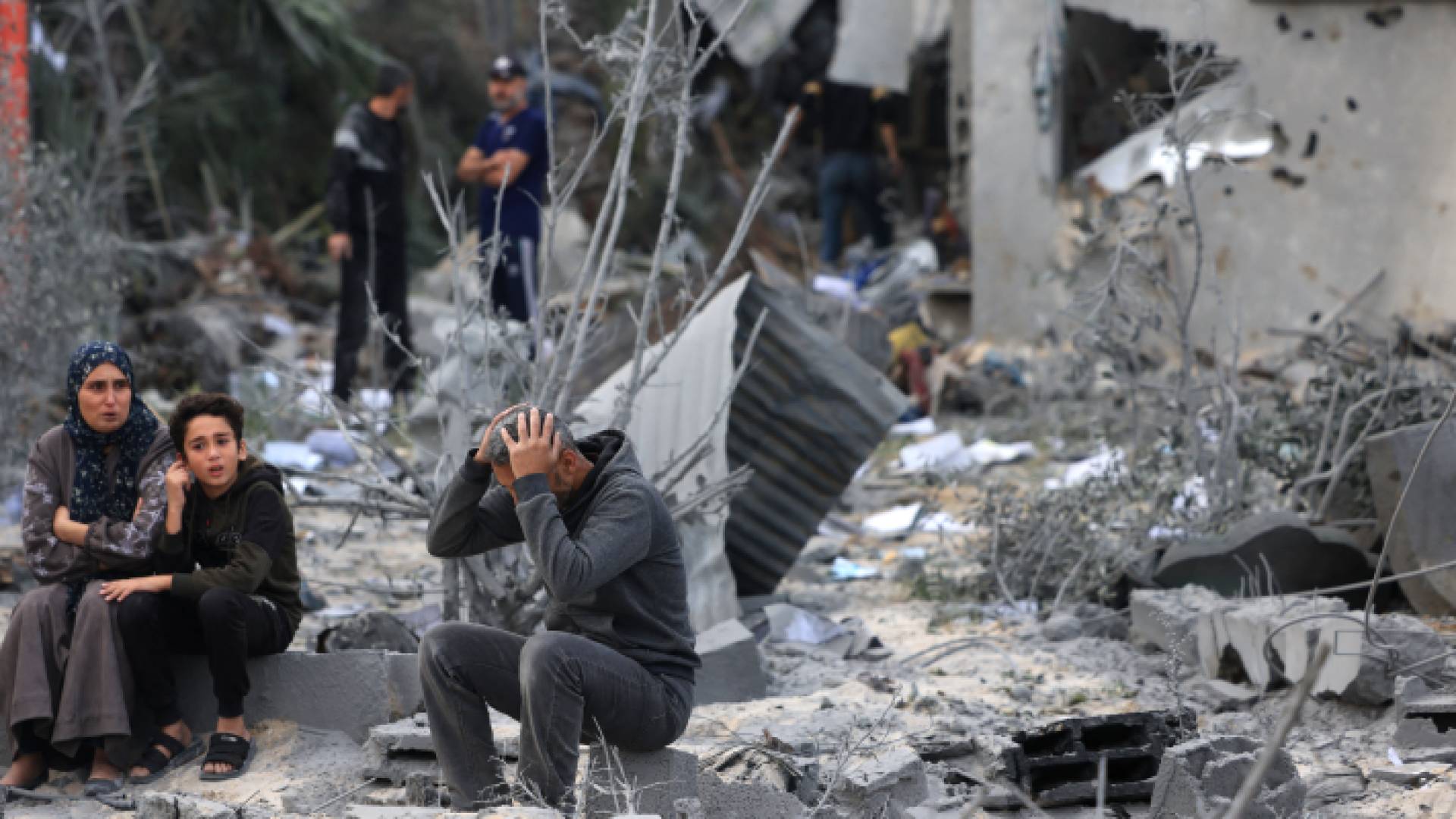 عائلة فلسطينية تجلس على ركام منزلها المدمر في غزة