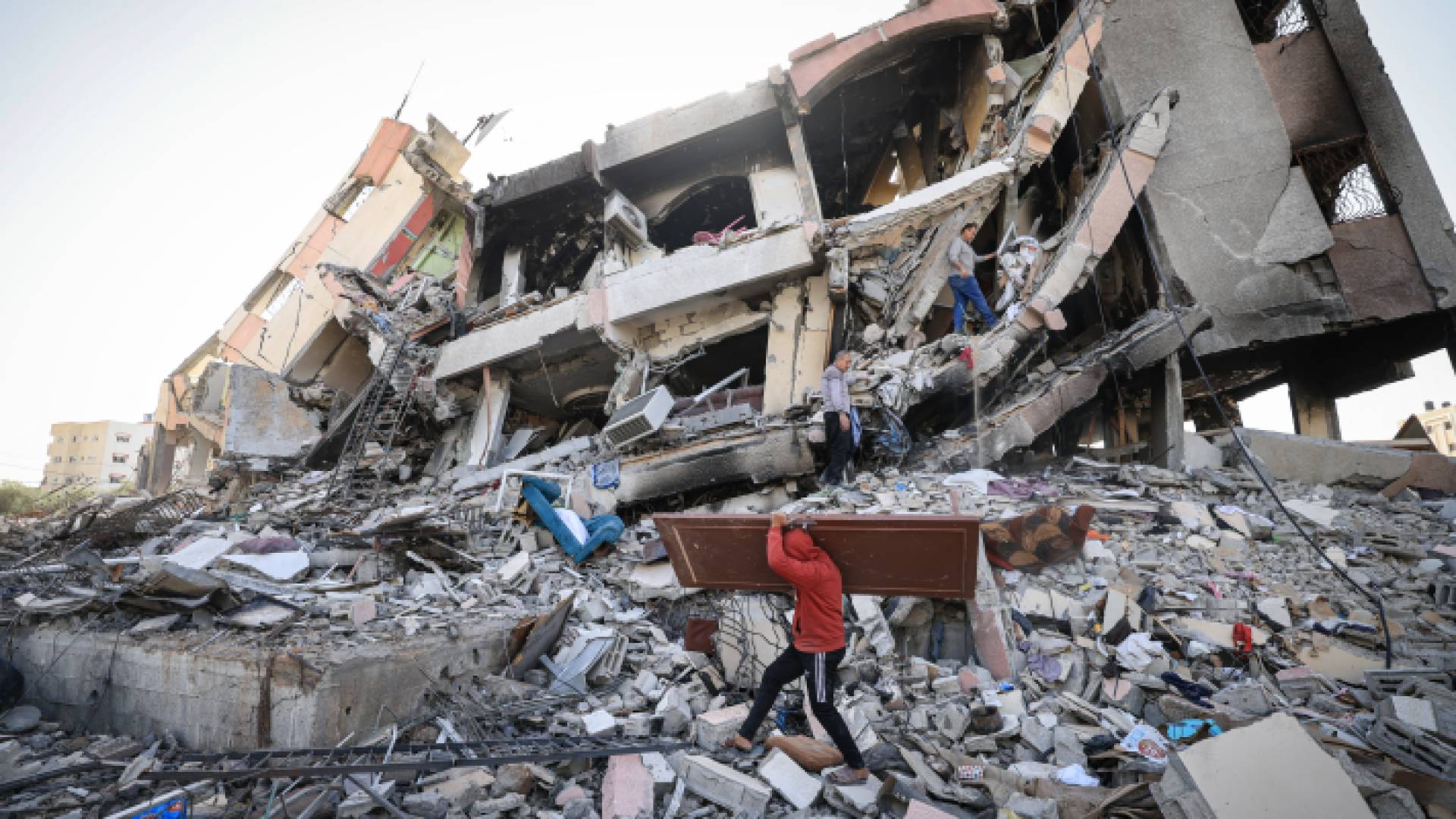 فلسطينيون يتفقدون أحد المنازل التي تعرضت للقصف في غزة