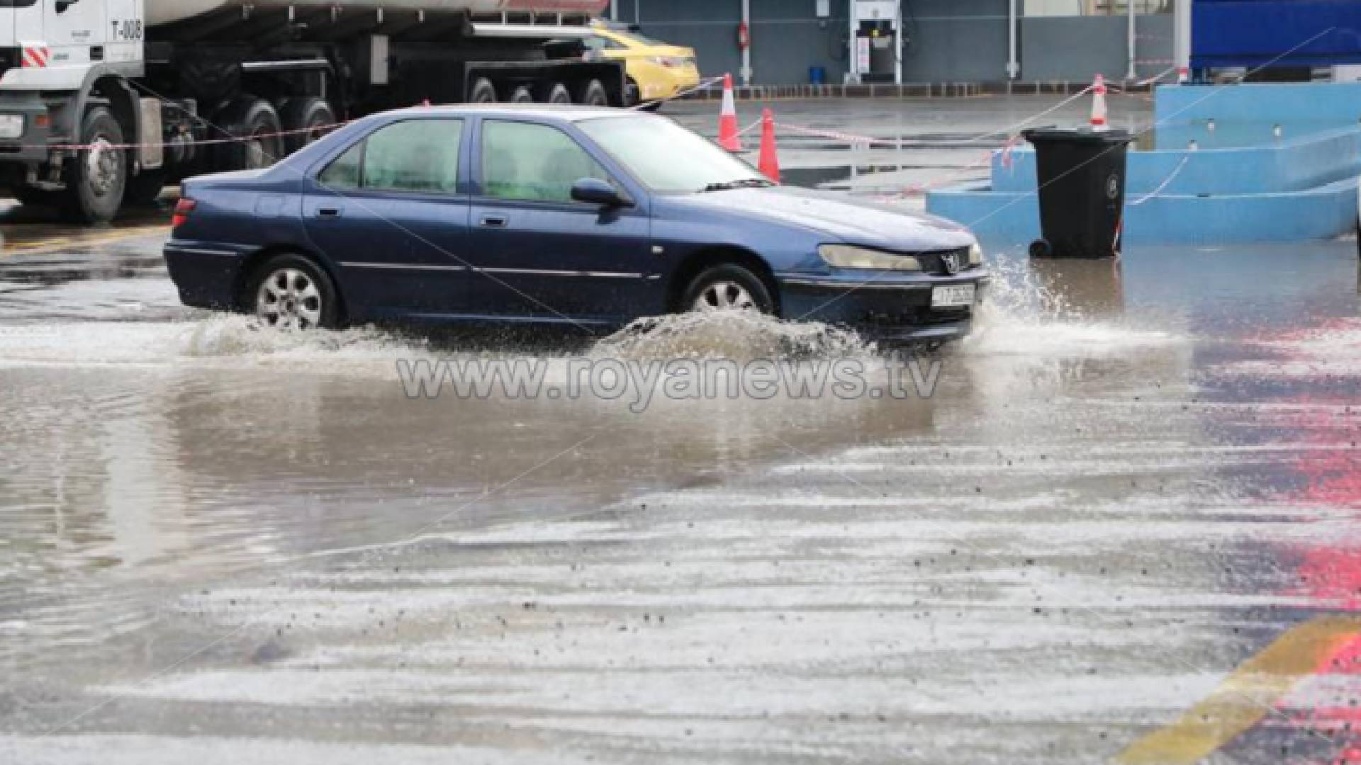 مركبة تسير في أحد شوارع العاصمة عمان بعد هطول الأمطار