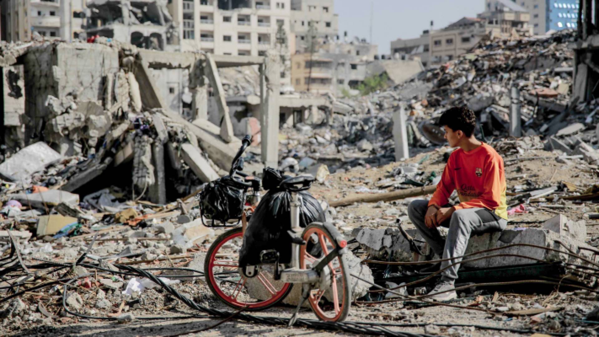 فتى فلسطيني ينظر إلى الدمار الذي خلفه الاحتلال في غزة