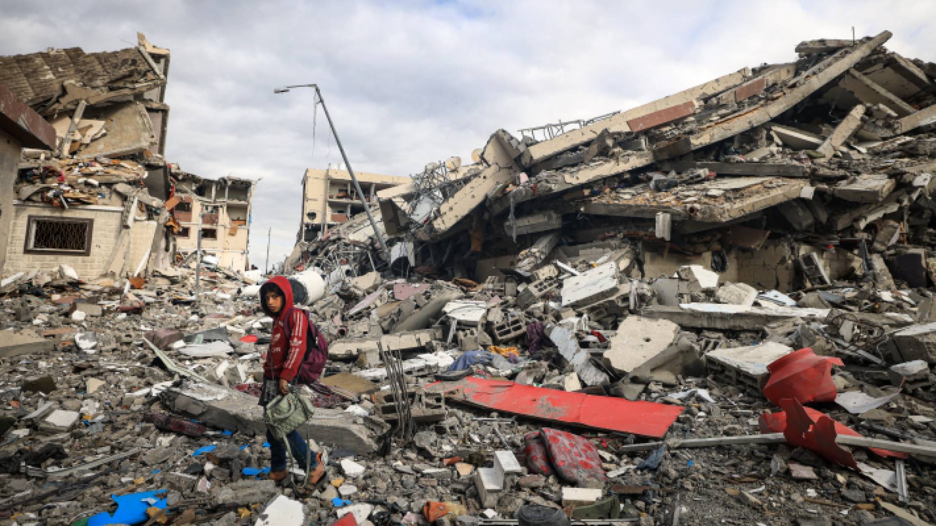 طفل فلسطيني أمام دمار خلفه قصف الاحتلال الإسرائيلي في قطاع غزة