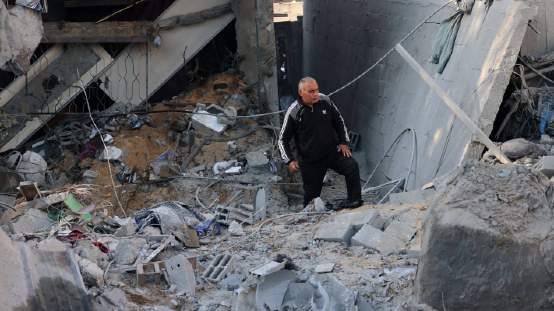 فلسطيني يقف عند مدخل منزله المدمر في قطاع غزة