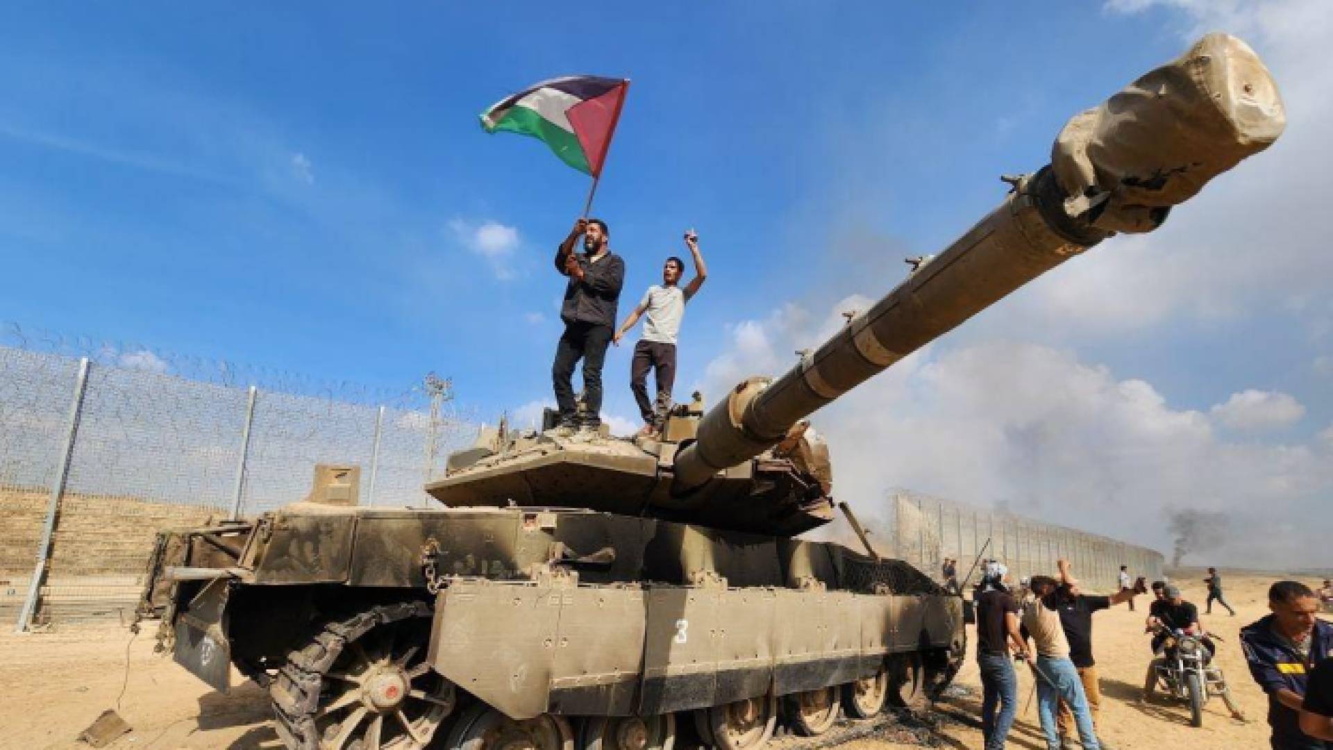 رفع علم فلسطين فوق دبابة مدمرة للاحتلال