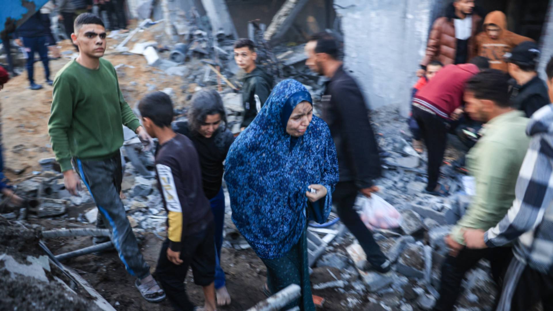 فلسطينيون في قطاع غزة على أنقاض منازلهم بعد قصفها