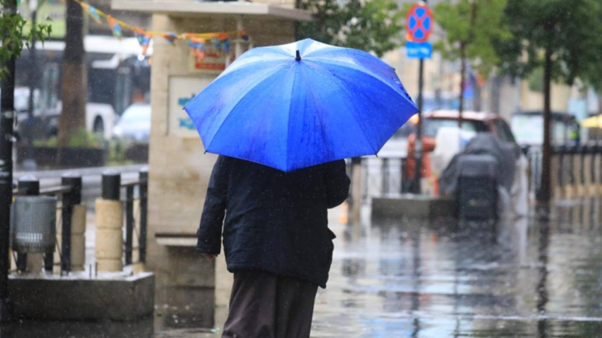 شخص يحمل مظلة في أحد شورع العاصمة عمان