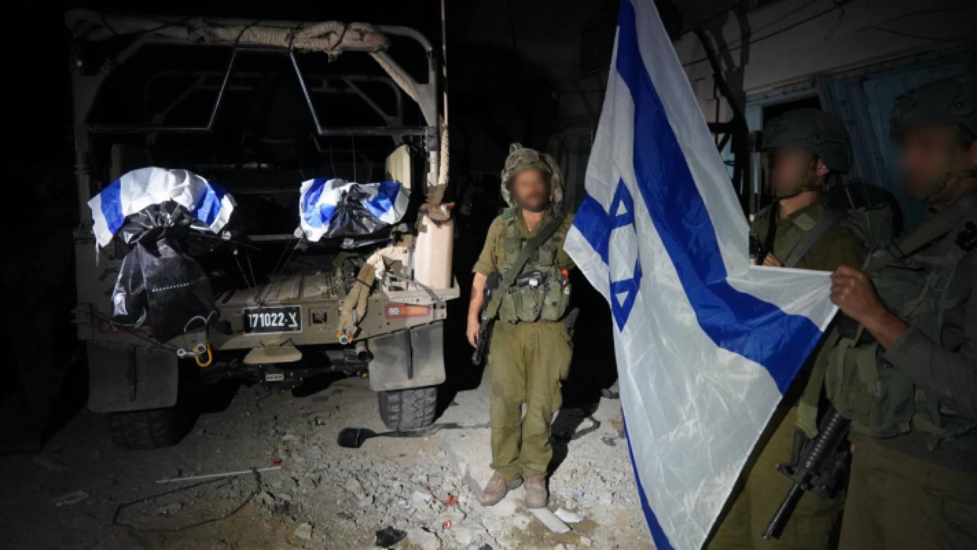 جنود من جيش الاحتلال يرفعون علم الكيان بجانب جثتي المحتجزين