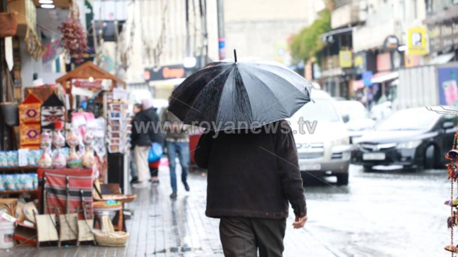 شخص يحمل مظلة في أحد شورع العاصمة عمان