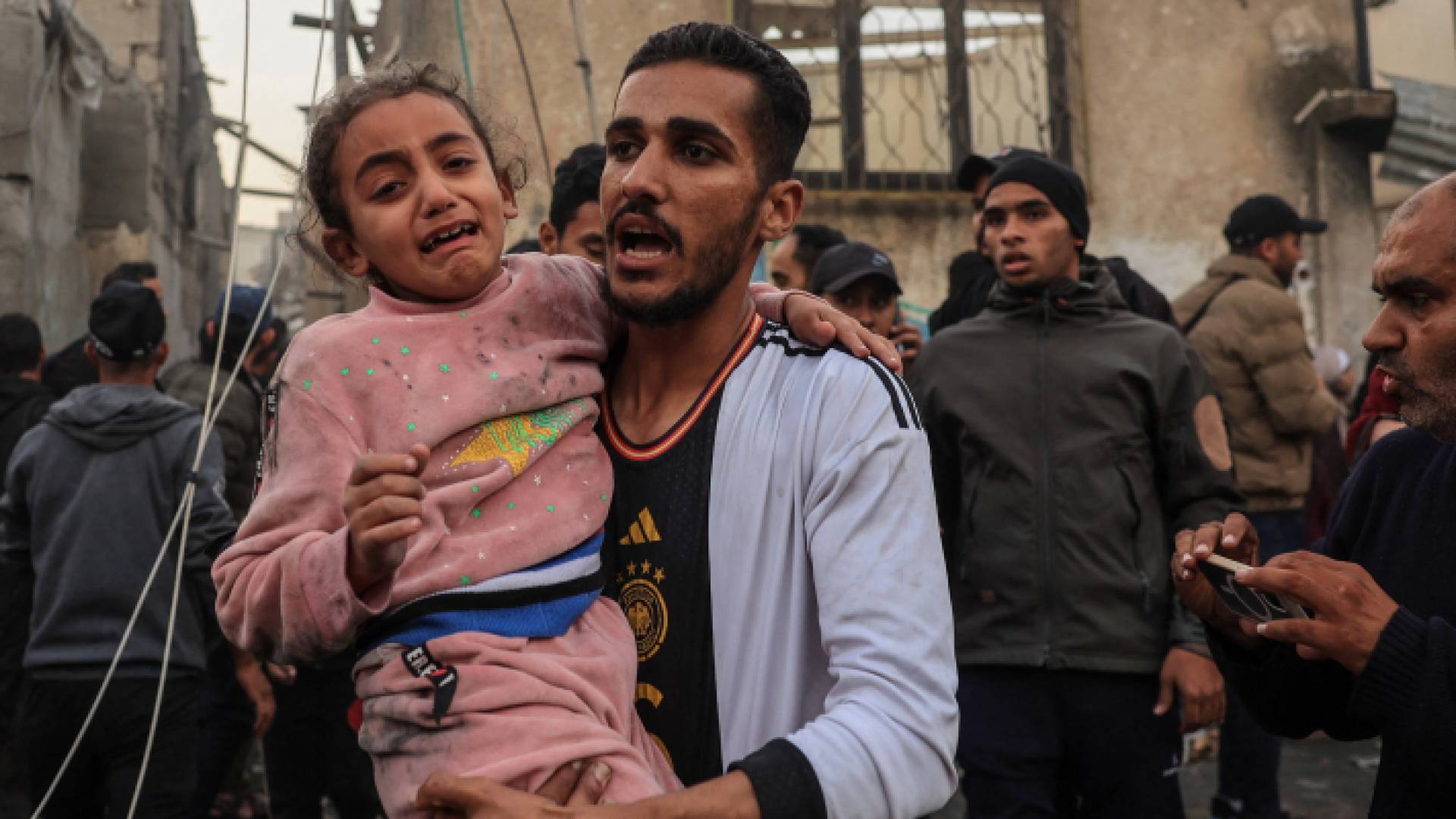 فلسطيني يحمل طفلته في قطاع غزة بعد استهداف منزله