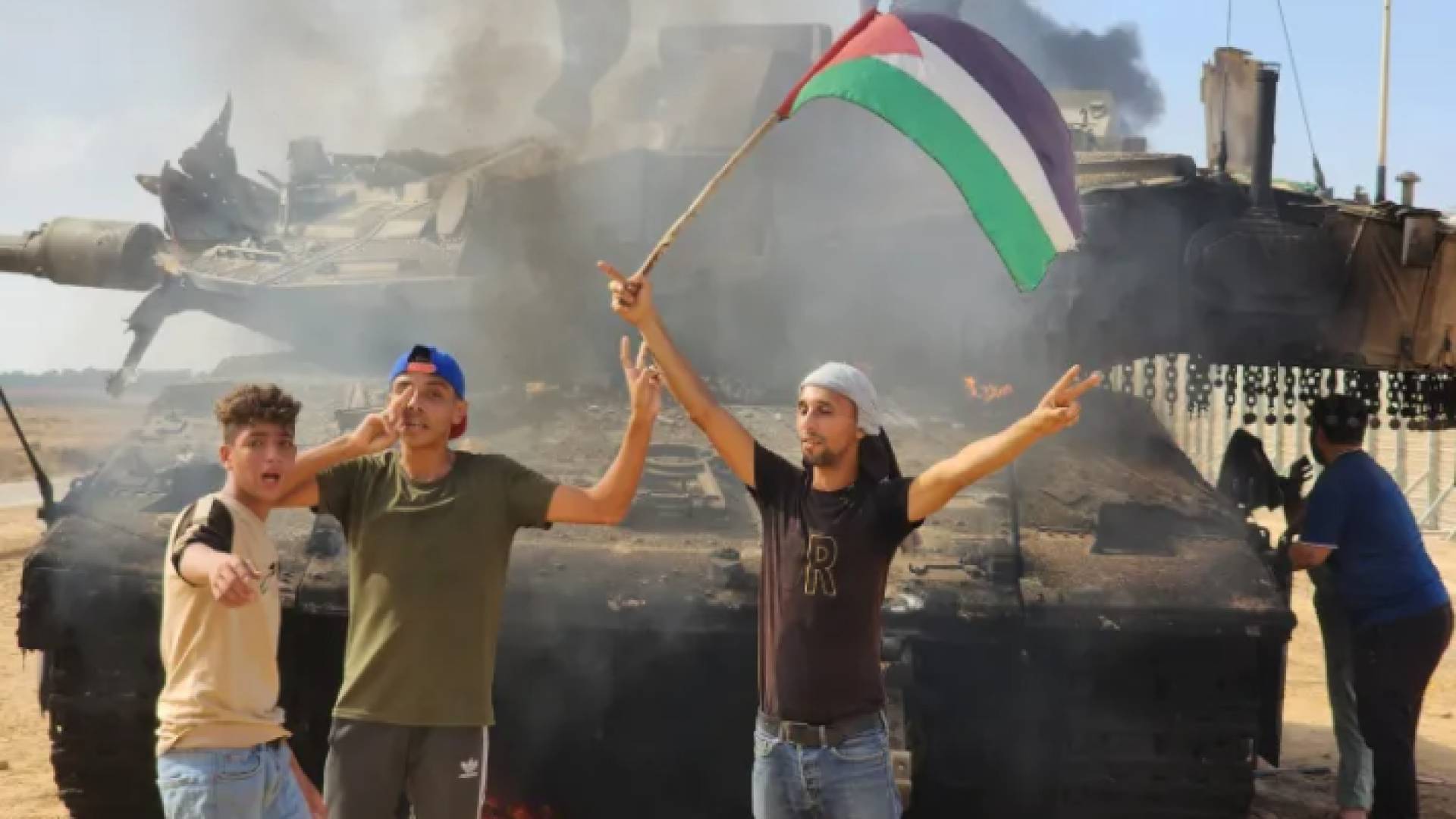 فلسطينيون يحتفلون فوق دبابة أحرقها المقاومون في قطاع غزة