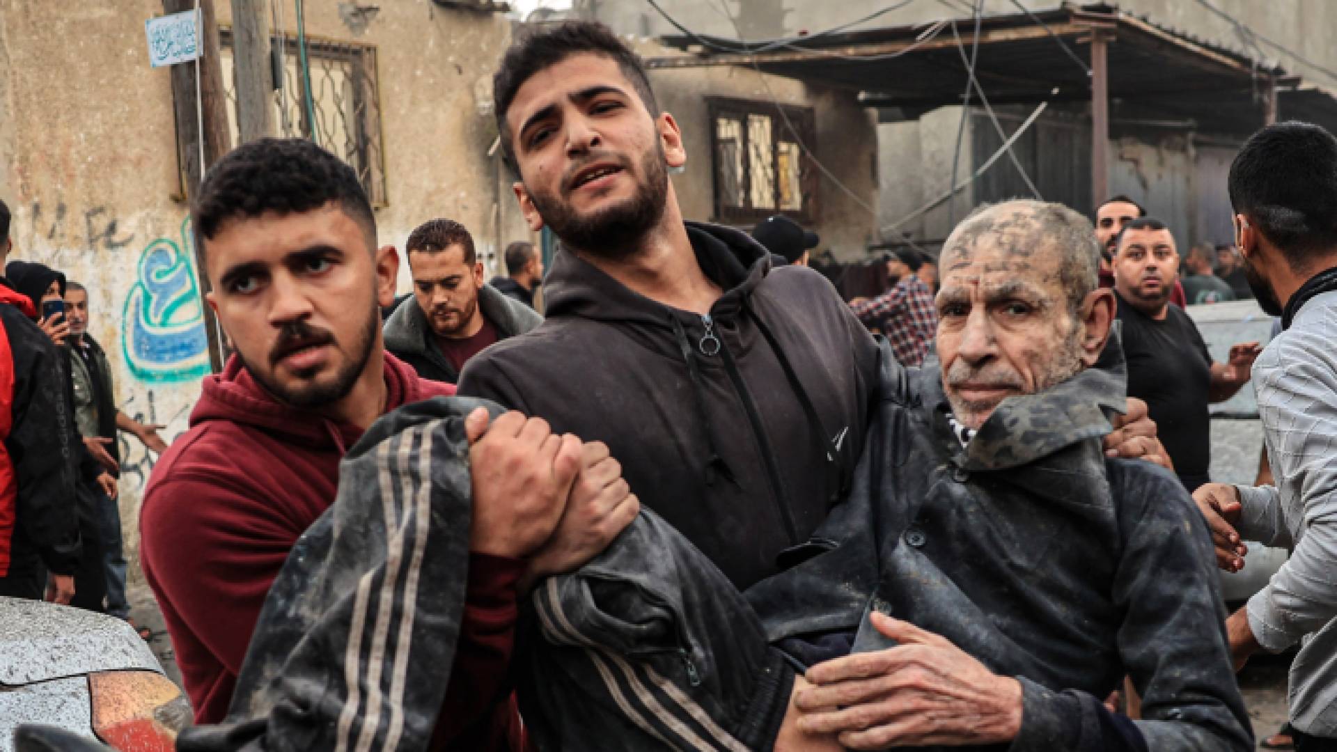 فلسطيني يحمل مصابا بقصف الاحتلال الإسرائيلي على قطاع غزة