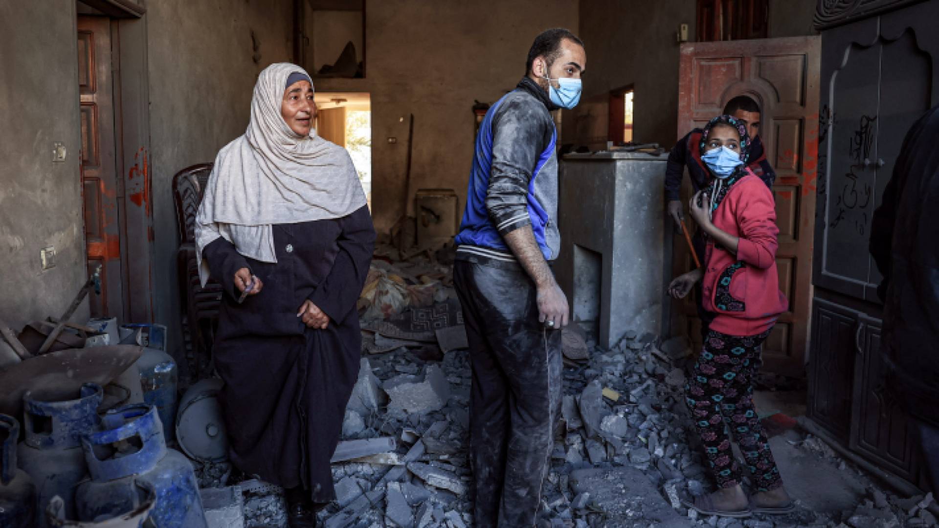 فلسطينيون يتفقدون منزلا تعرض للقصف في غزة - AFP