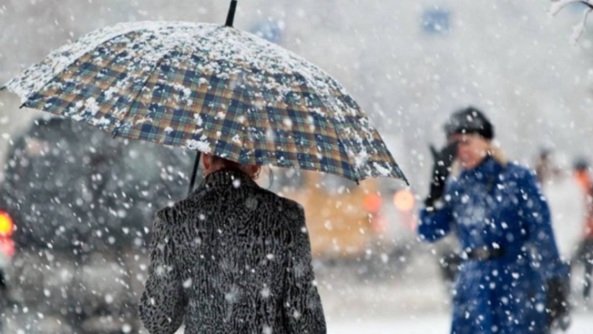 سيدة تسير وسط تساقط زخات ثلجية - أرشيفية