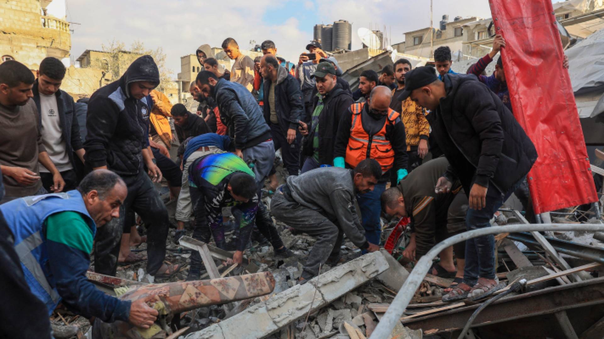 فلسطينيون يبحثون عن شهداء وناجين وسط أنقاض مباني قصفه الاحتلال في رفح - AFP