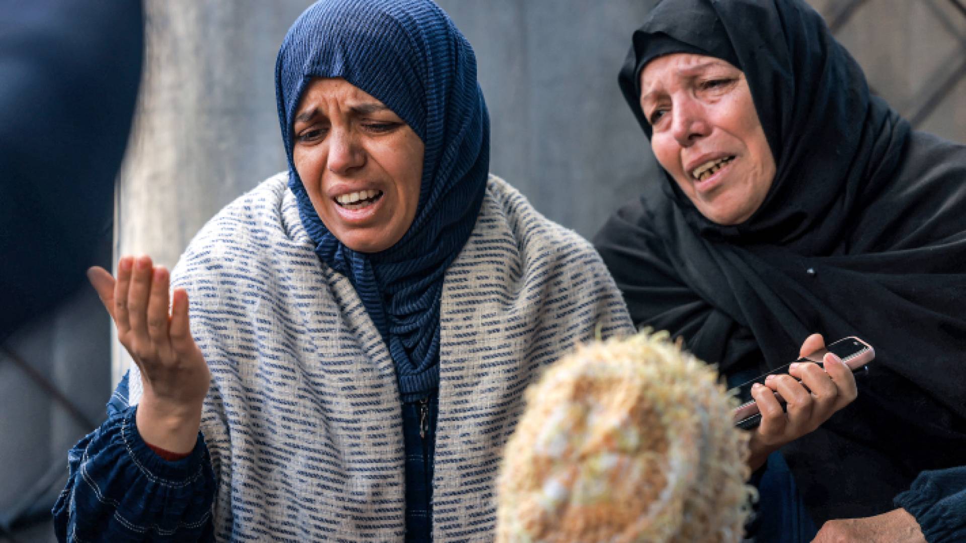 فلسطينيتان تبكيان حزنا على شهداء ارتقوا بقصف للاحتلال على قطاع غزة