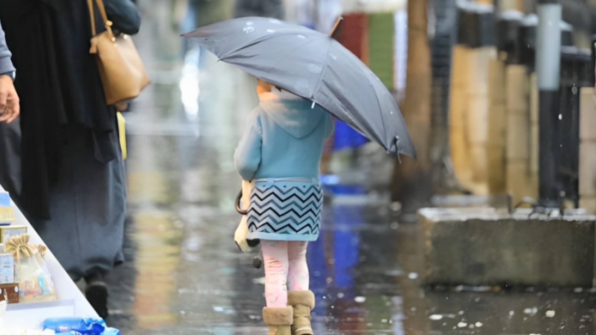 طفلة تحمل مظلة وسط أجواء ماطرة - أرشيفية