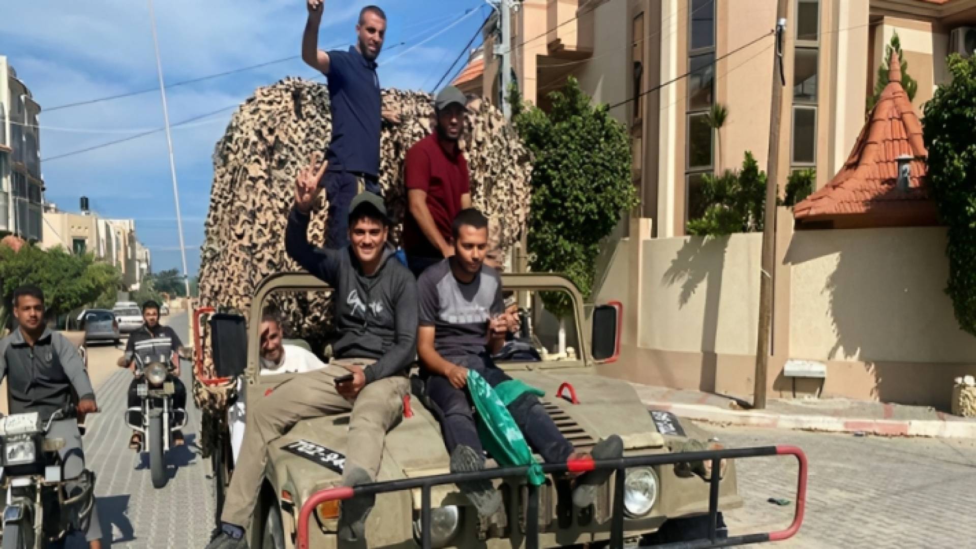 فلسطينيون يرفعون إشارة النشر فوق جيب للاحتلال