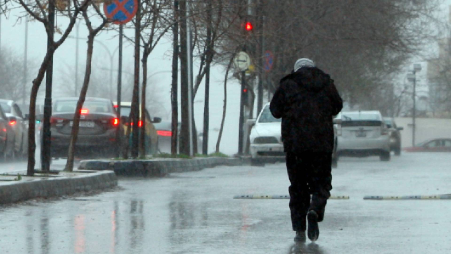 مواطن يسير في الشارع العام وسط الأجواء الباردة