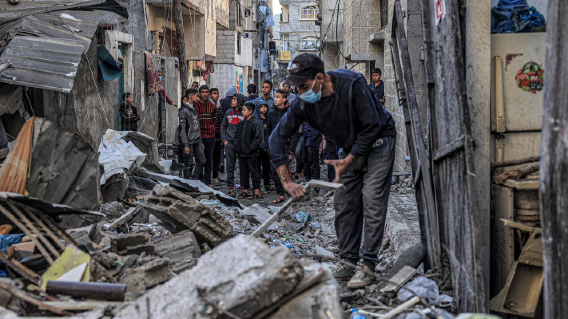 فلسطيني يحاول رفع أنقاض منزله الذي هدم على يد قوات الاحتلال الإسرائيلي في قطاع غزة