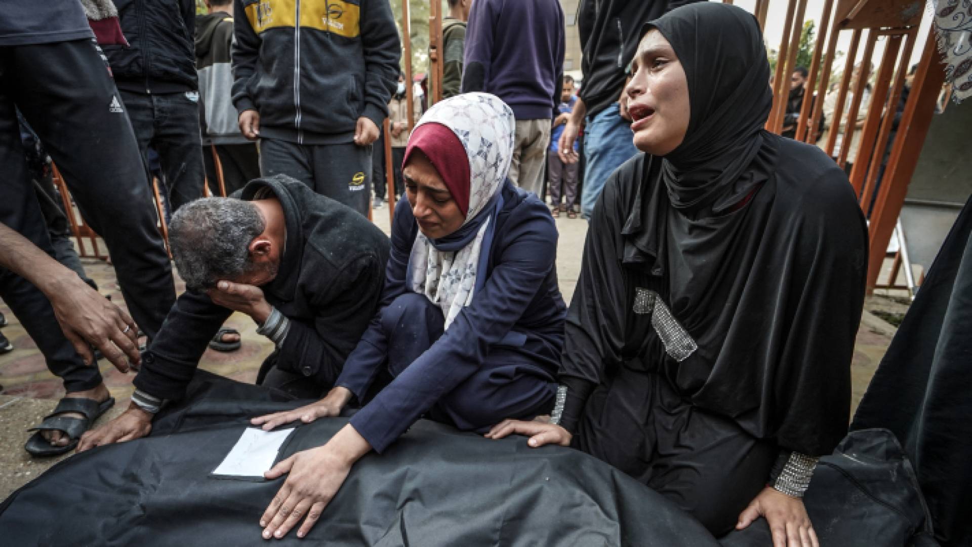 فلسطينيون يبكون بجانب شهيد في قطاع غزة