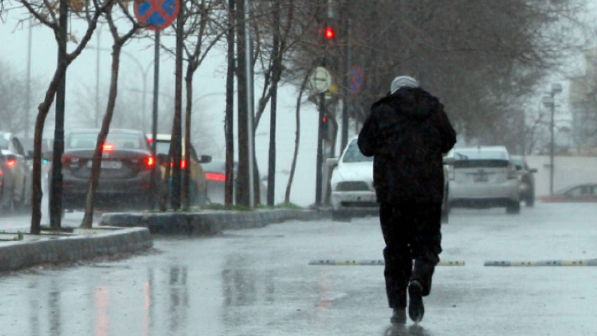 مواطن يسير في الشارع العام وسط الأجواء الباردة