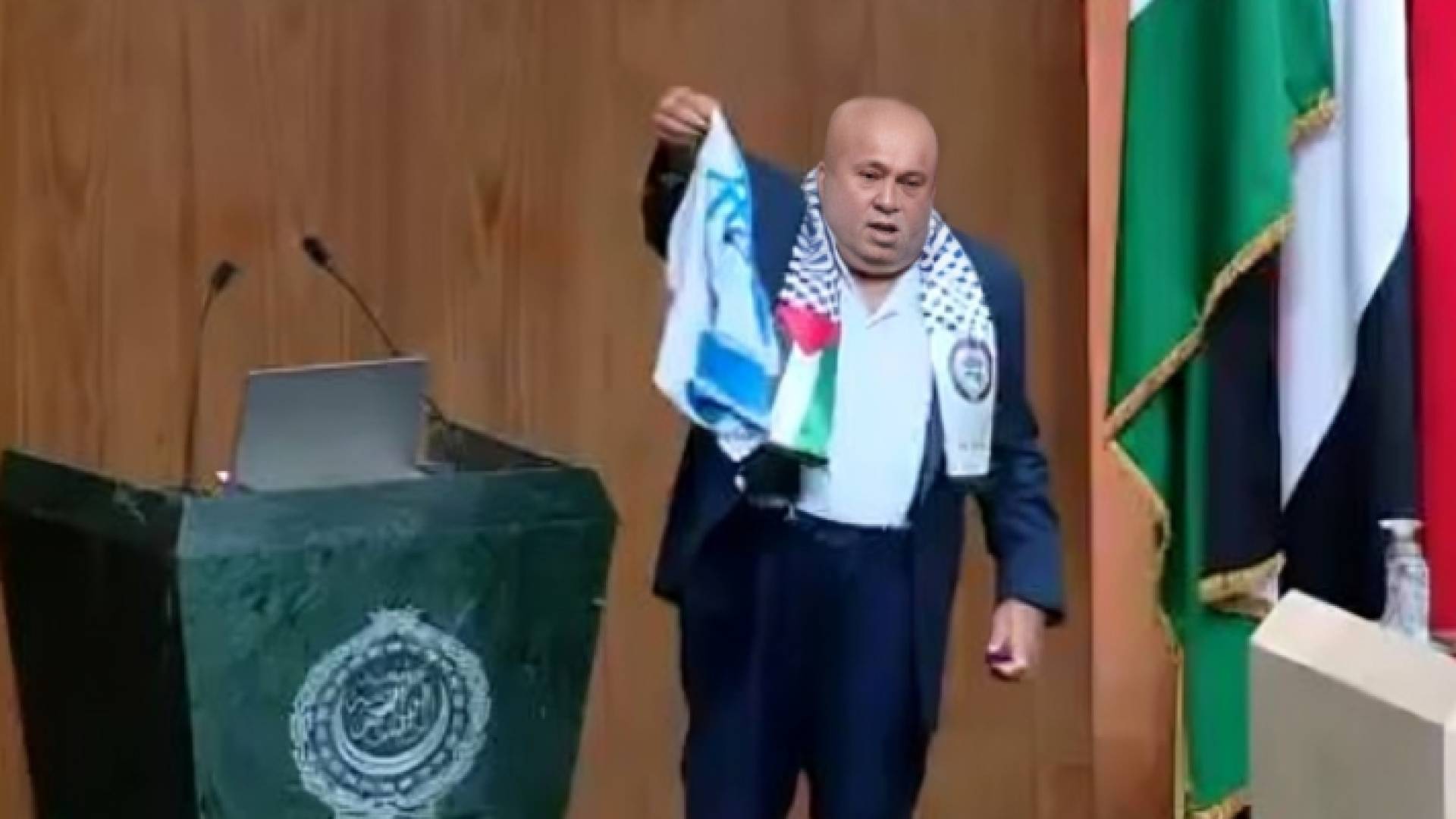 النائب خليل عطية أثناء إحراقه علم كيان الاحتلال