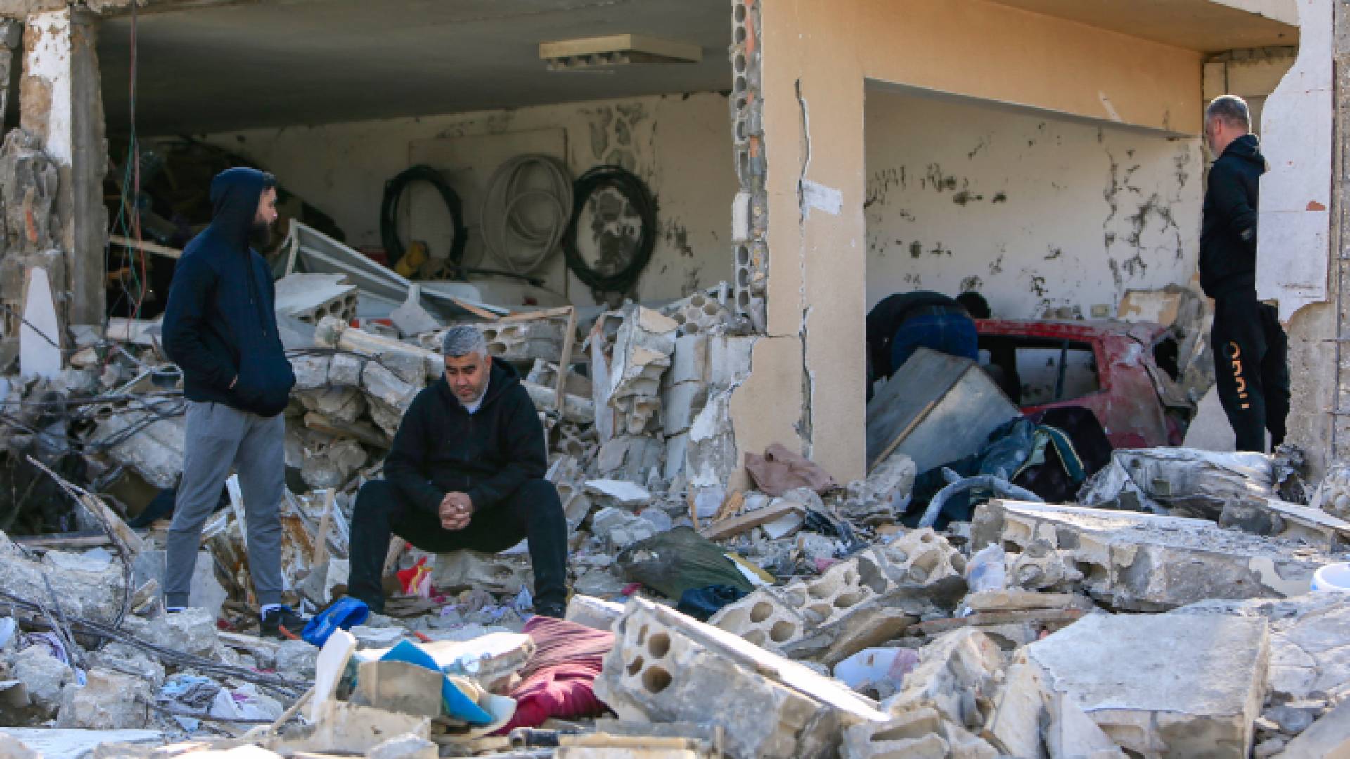 فلسطينيون بالقر من منزل دمره قصف الاحتلال