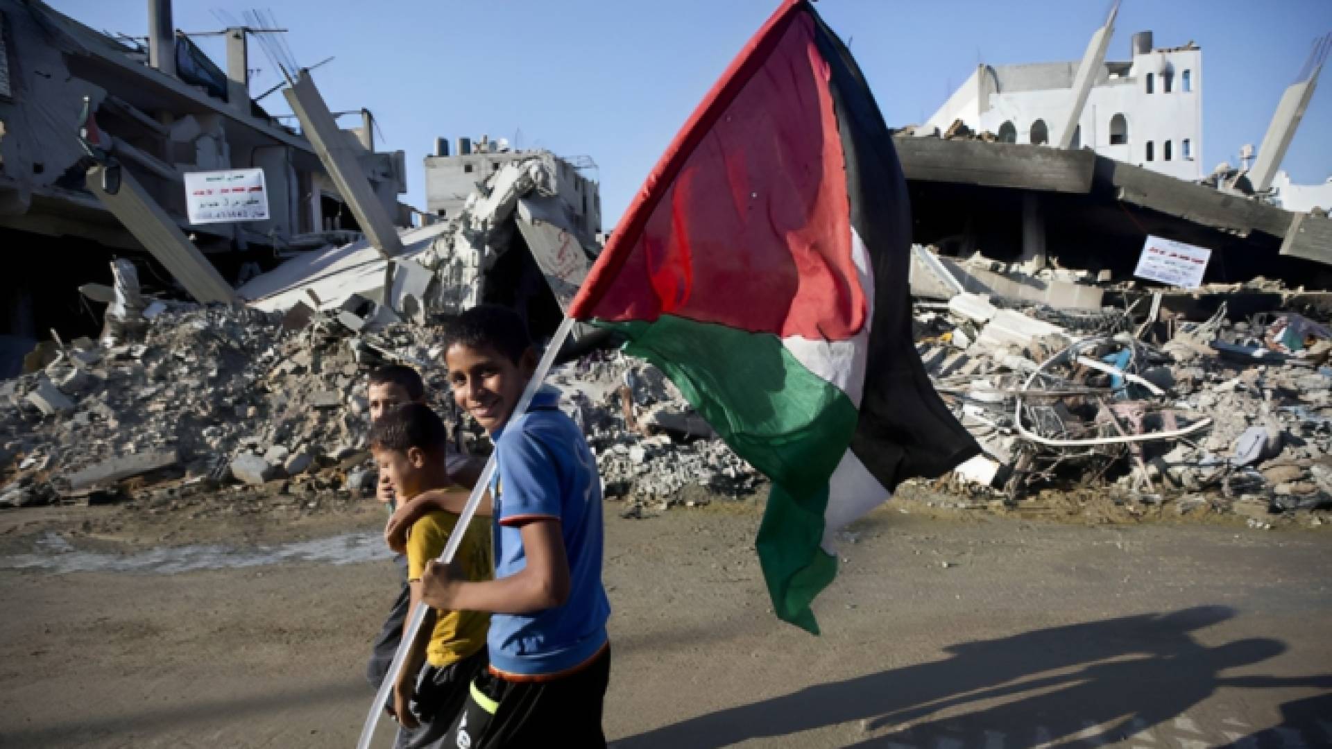 طفل فلسطيني يرفع علم بلاده بين الركام في غزة