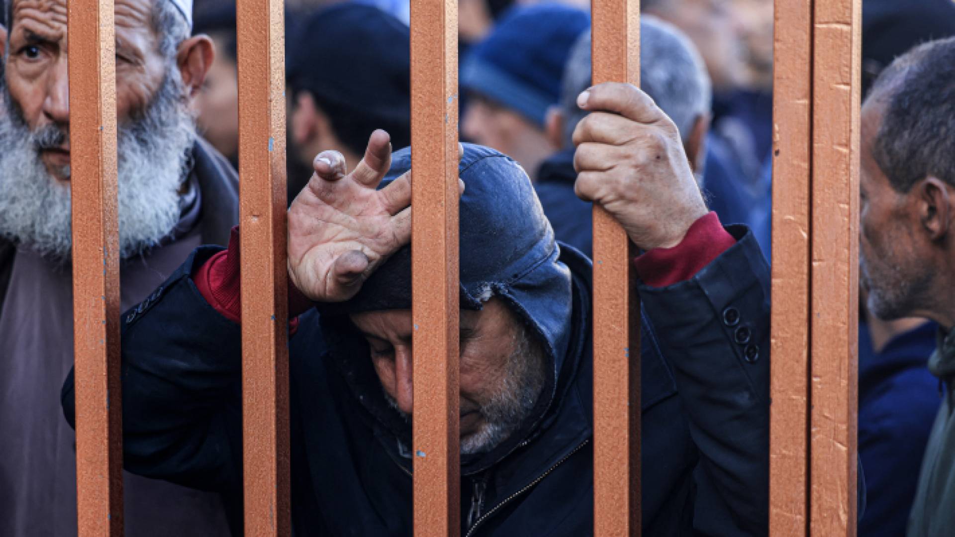 فلسطينيون يقفون عند مدخل مشرحة مركز ناصر الطبي في قطاع غزة للتعرف على جثامين أقارب لهم