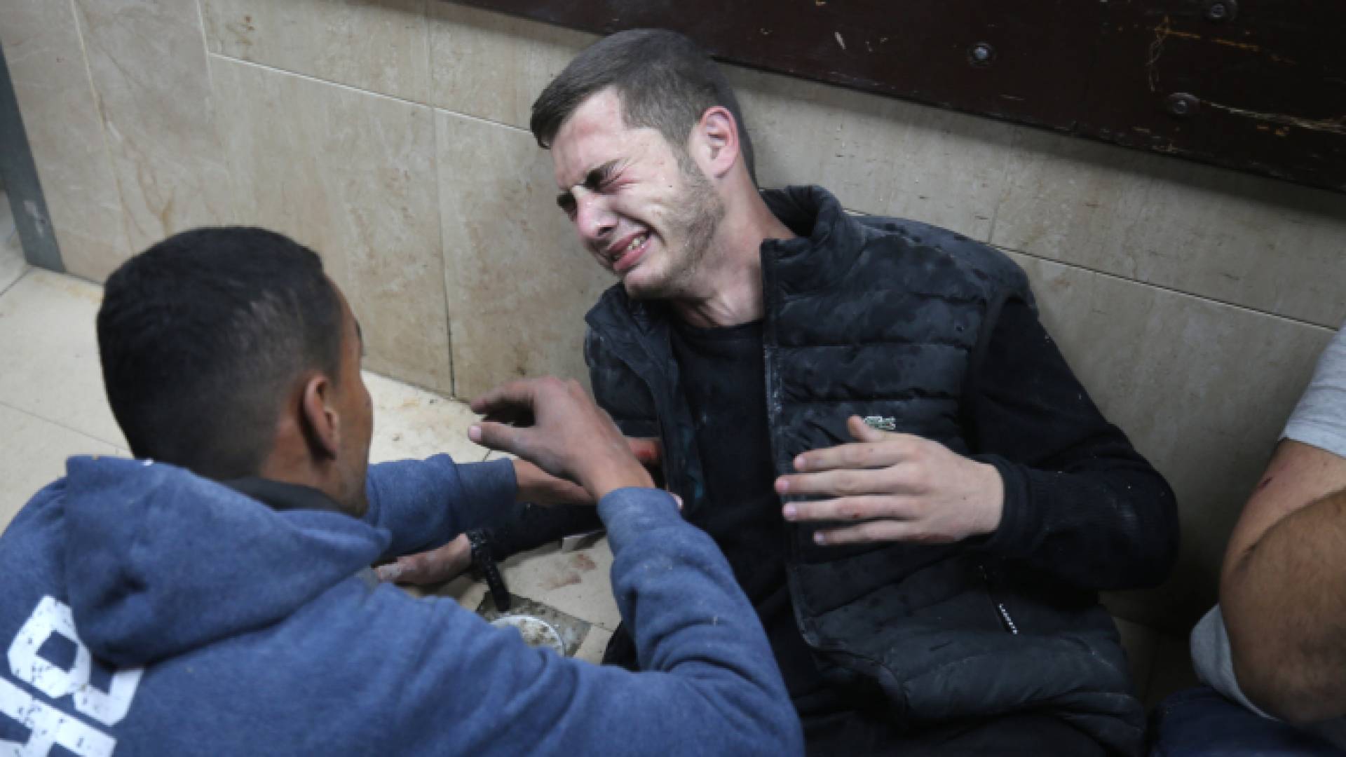 فلسطينيان في مستشفى الأقصى بعد غارة للاحتلال على منزل في دير البلح - AFP