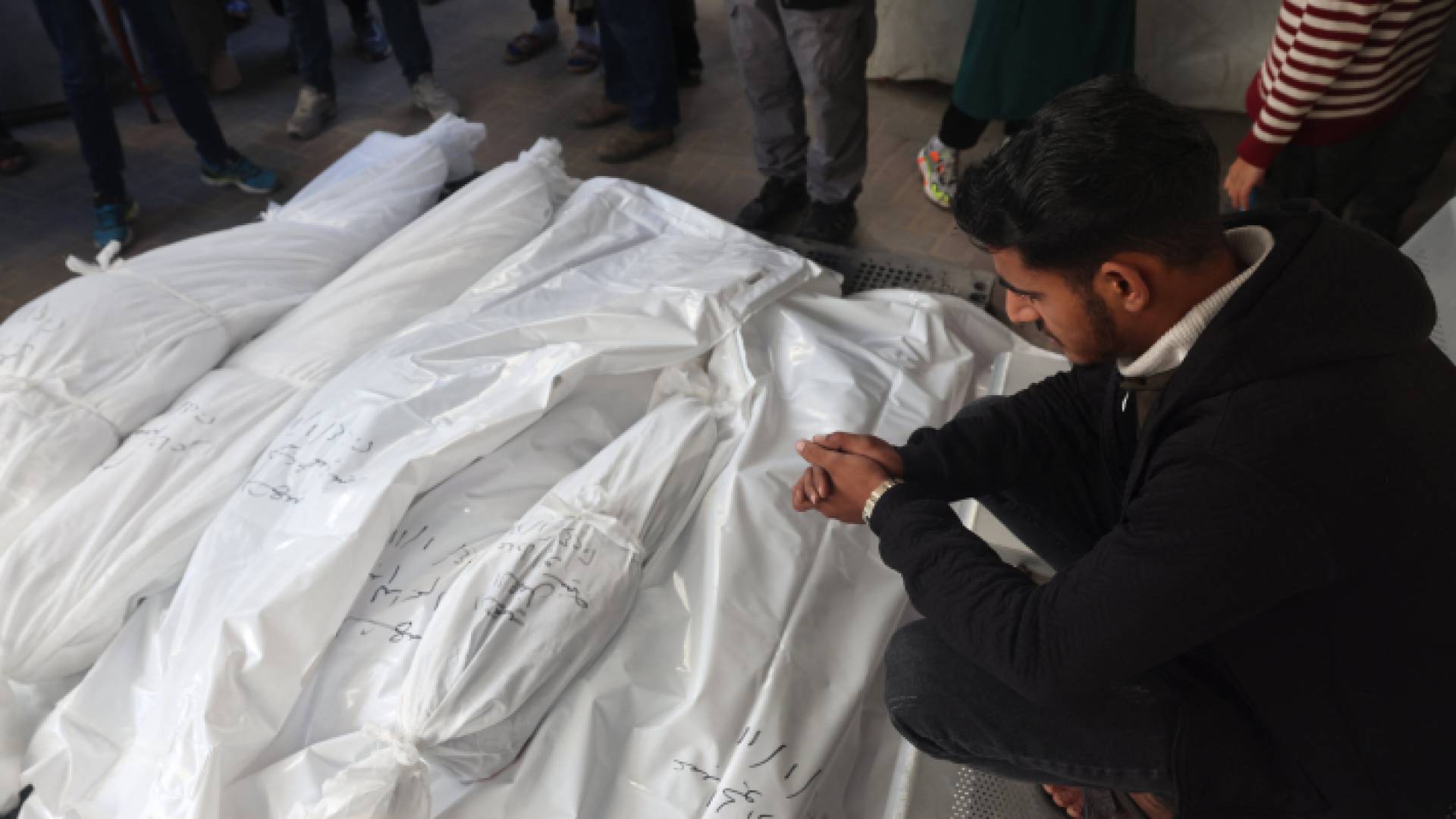 فلسطيني أمام أكفان في قطاع غزة