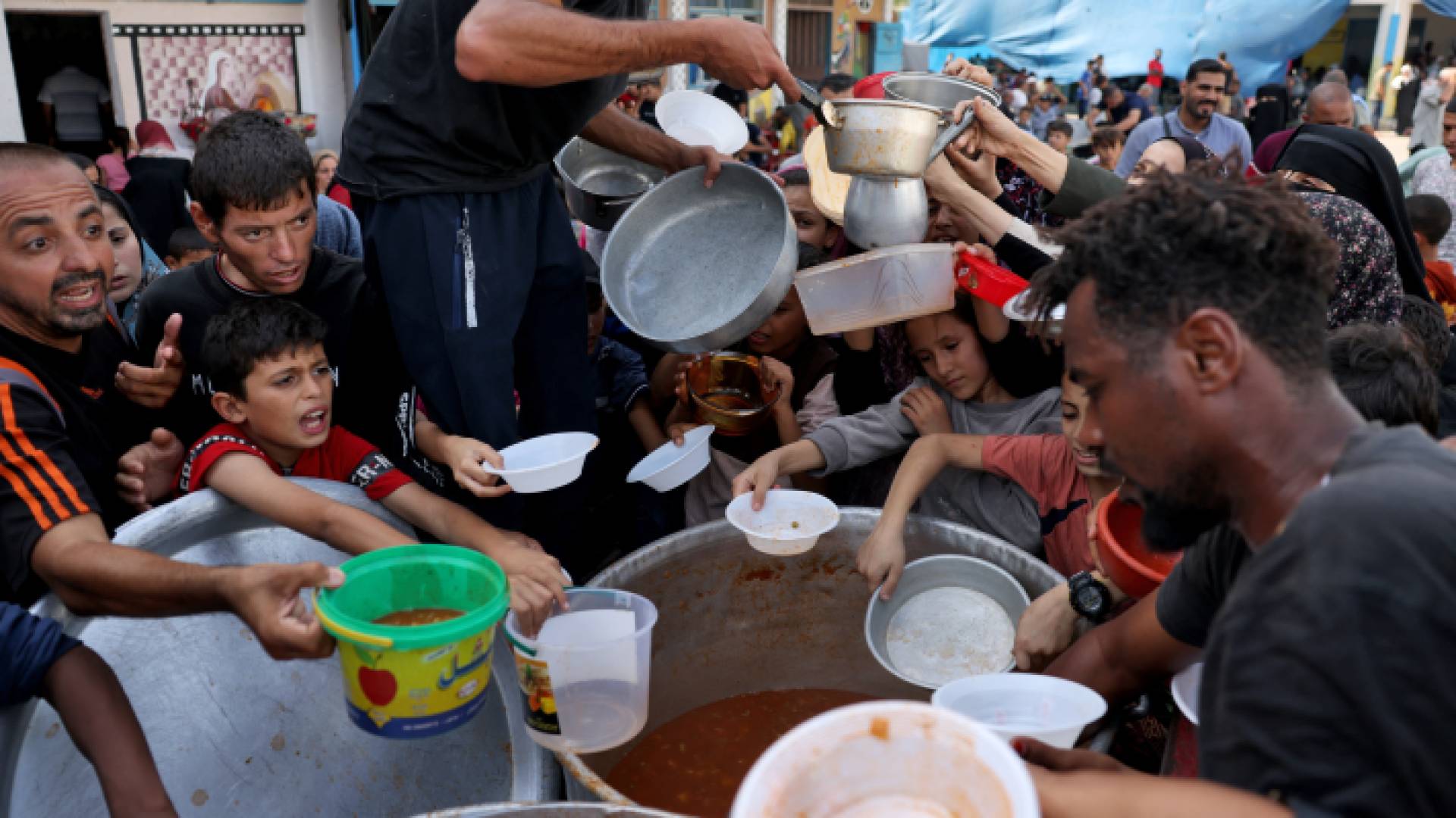 أطفال فلسطينيون يحصلون على الطعام في مدرسة تابعة للأمم المتحدة في رفح