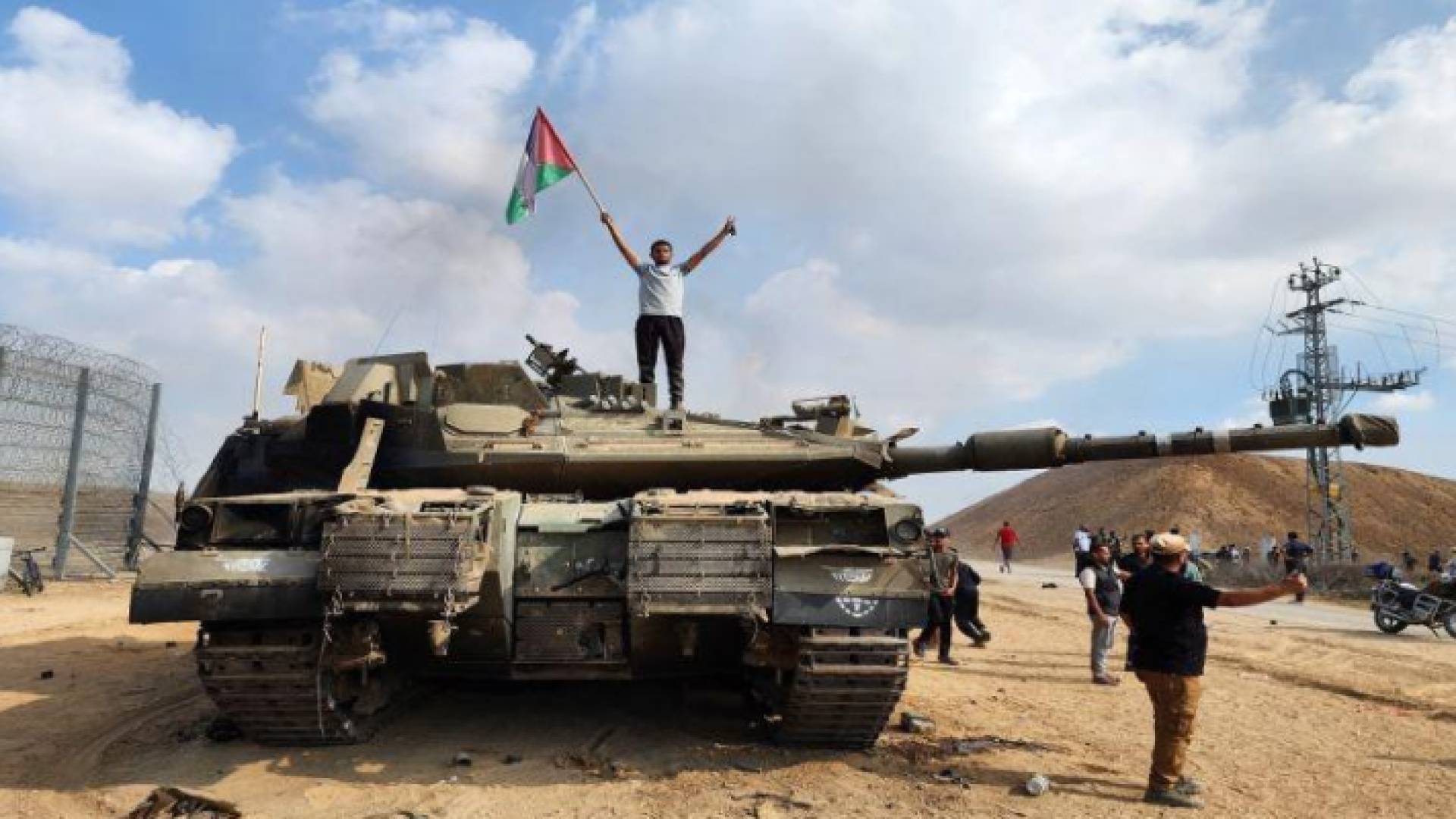 فلسطيني يرفع علم بلاده فوق دبابة مع بدء طوفان الأقصى