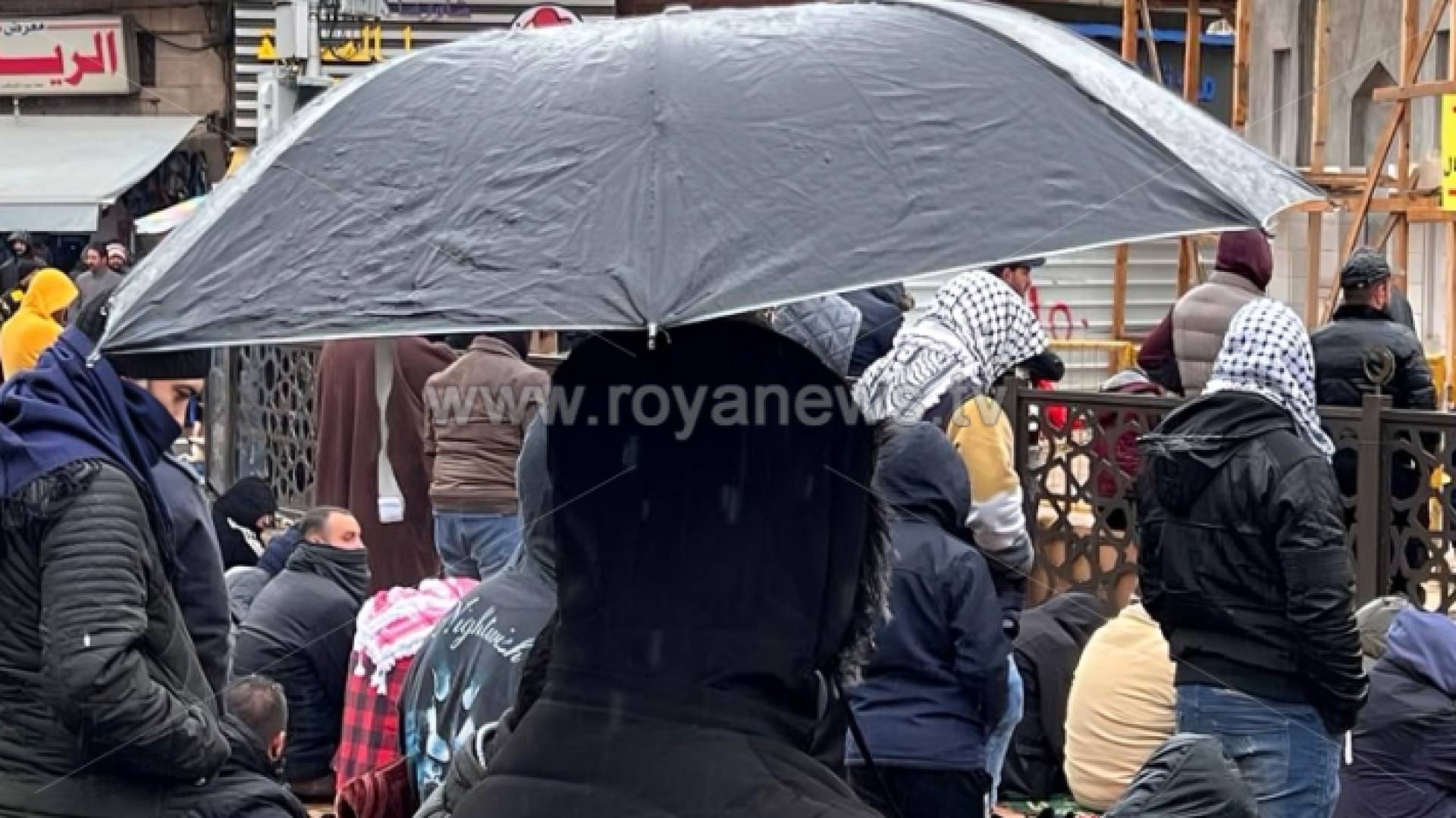 شخص يحمل مظلة في أحد شورع العاصمة عمان