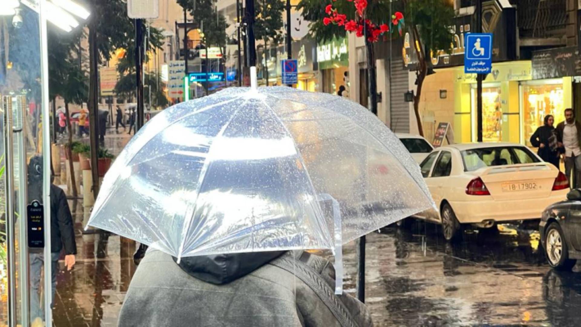 شخص يحمل مظلة في أحد شورع العاصمة عمان