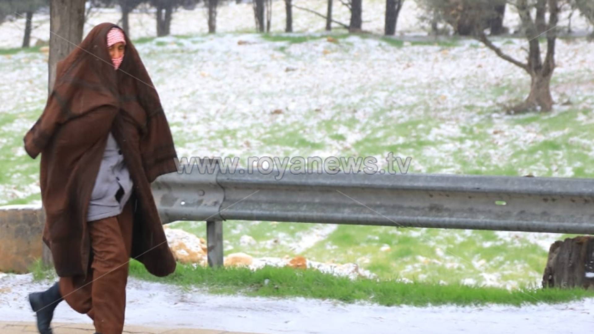 شخص يسير وسط تساقط زخات ثلجية