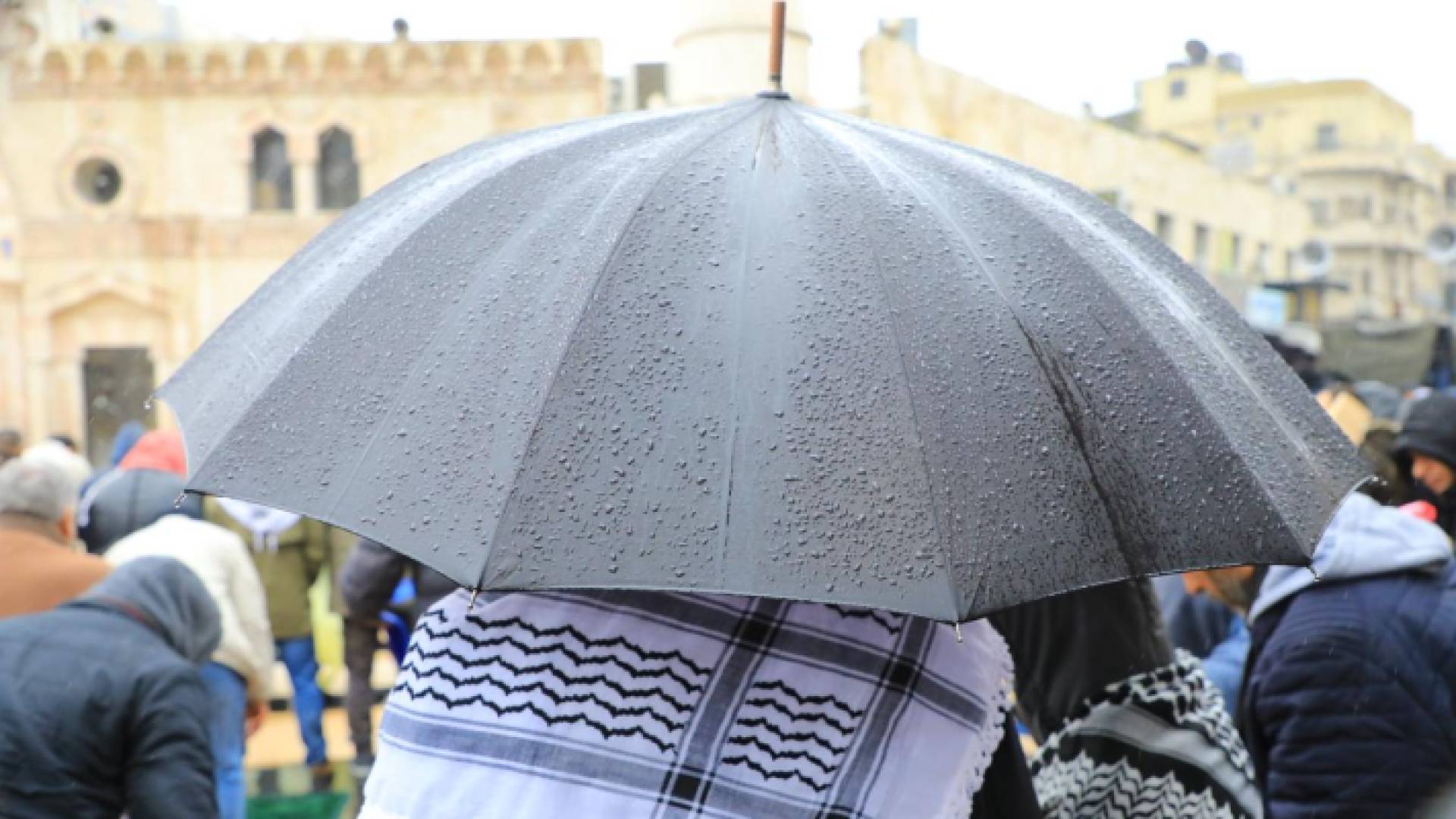 شخص يحمل مظلة وسط الأجواء الماطرة في العاصمة عمان