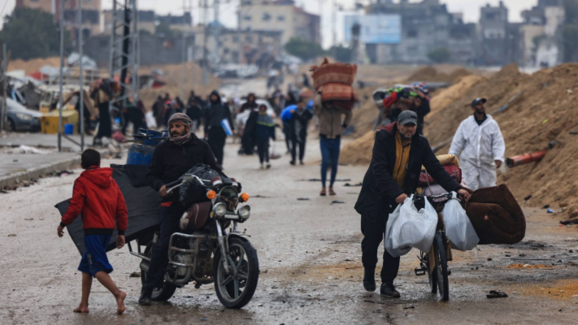 فلسطينيون يحملون بعض ممتلكاتهم في خان يونس - AFP