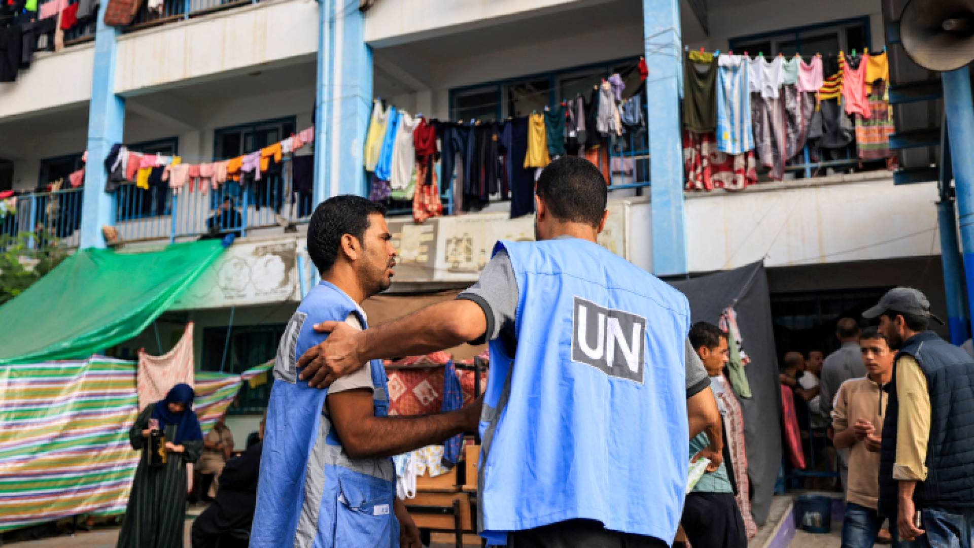 موظفون في الأونروا يقدمون مساعدات لفلسطينيين نازحين في قطاع غزة