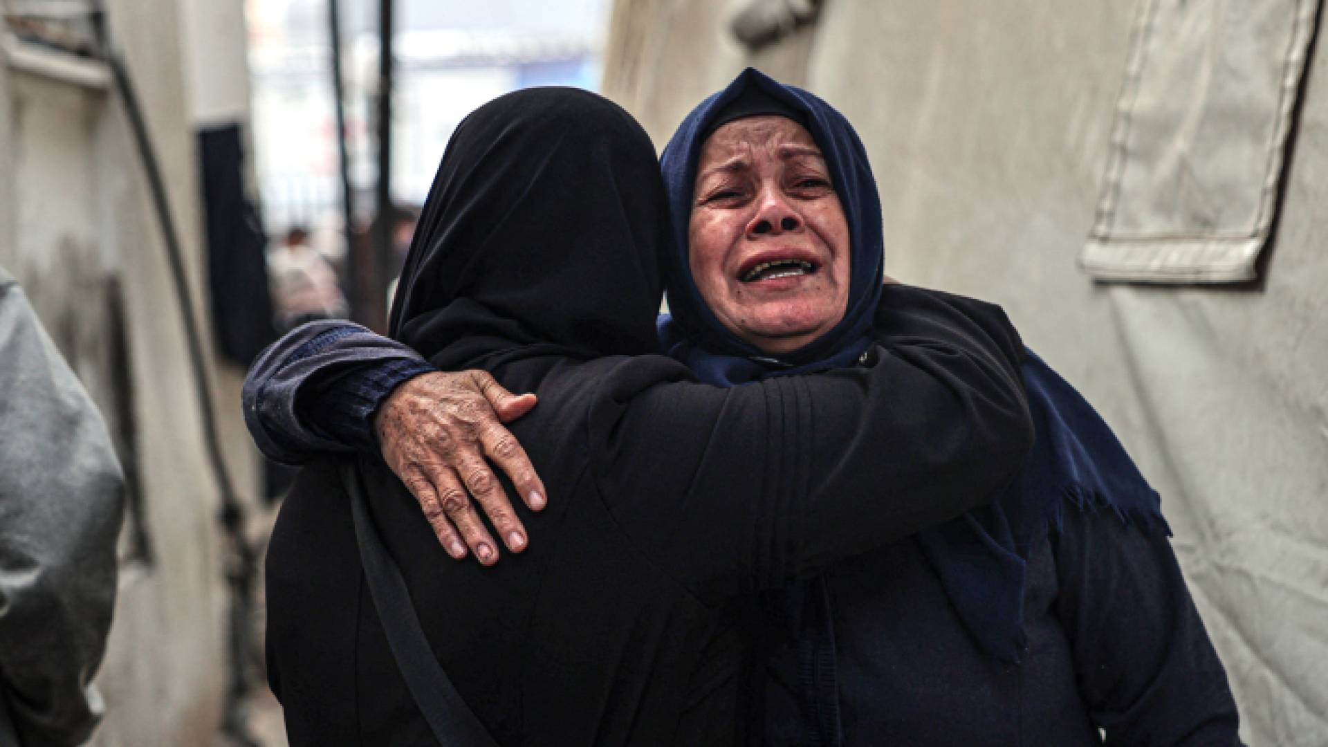 سيدات فلسطينيات يبكين بعد التعرف على جثث أقاربهم الذين قتلوا في قصف الاحتلال