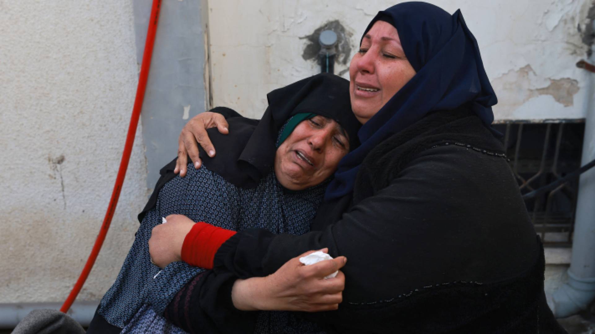 فلسطينيتان تبكيان بعد استشهاد أقارب لهما في قطاع غزة