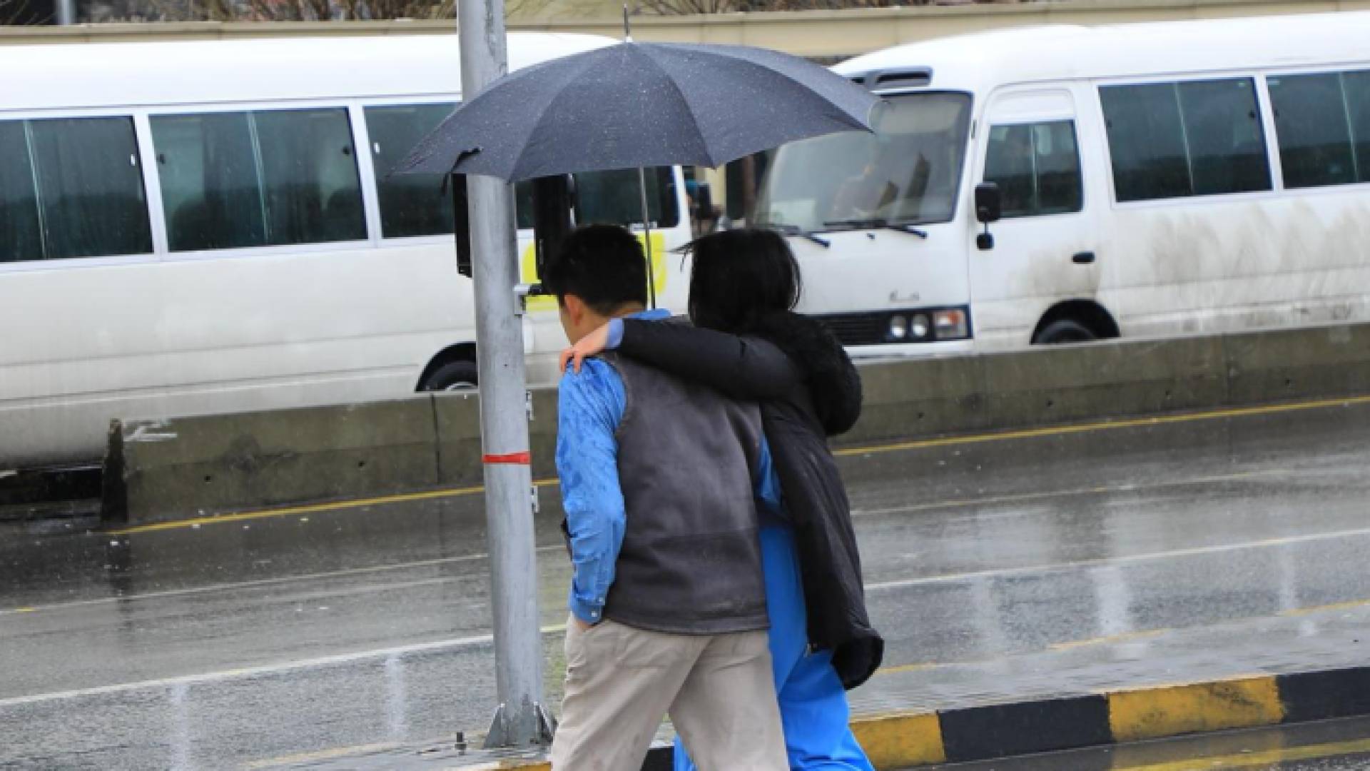 شخصان يحملان مظلة تحت الأمطار