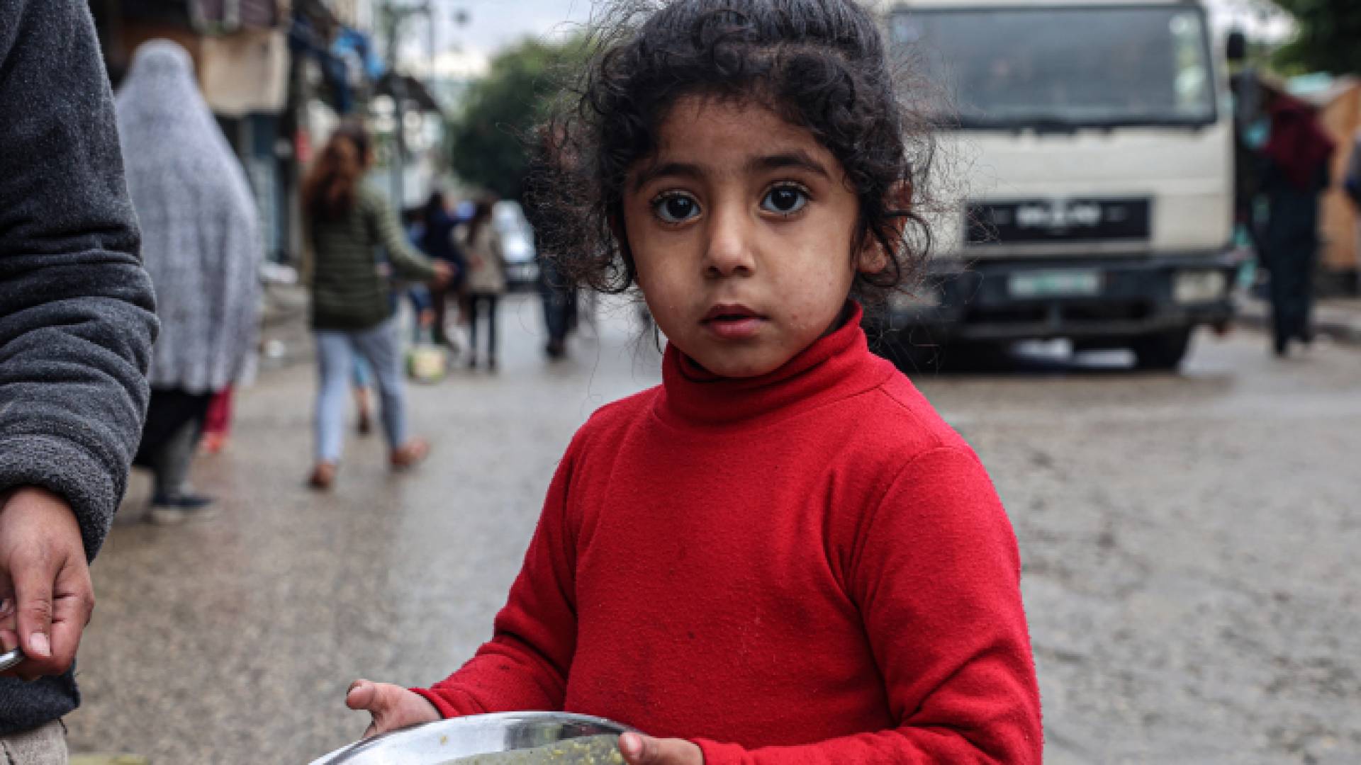 طفلة في غزة تحمل الطعام الذي حصلت عليه من المساعدات