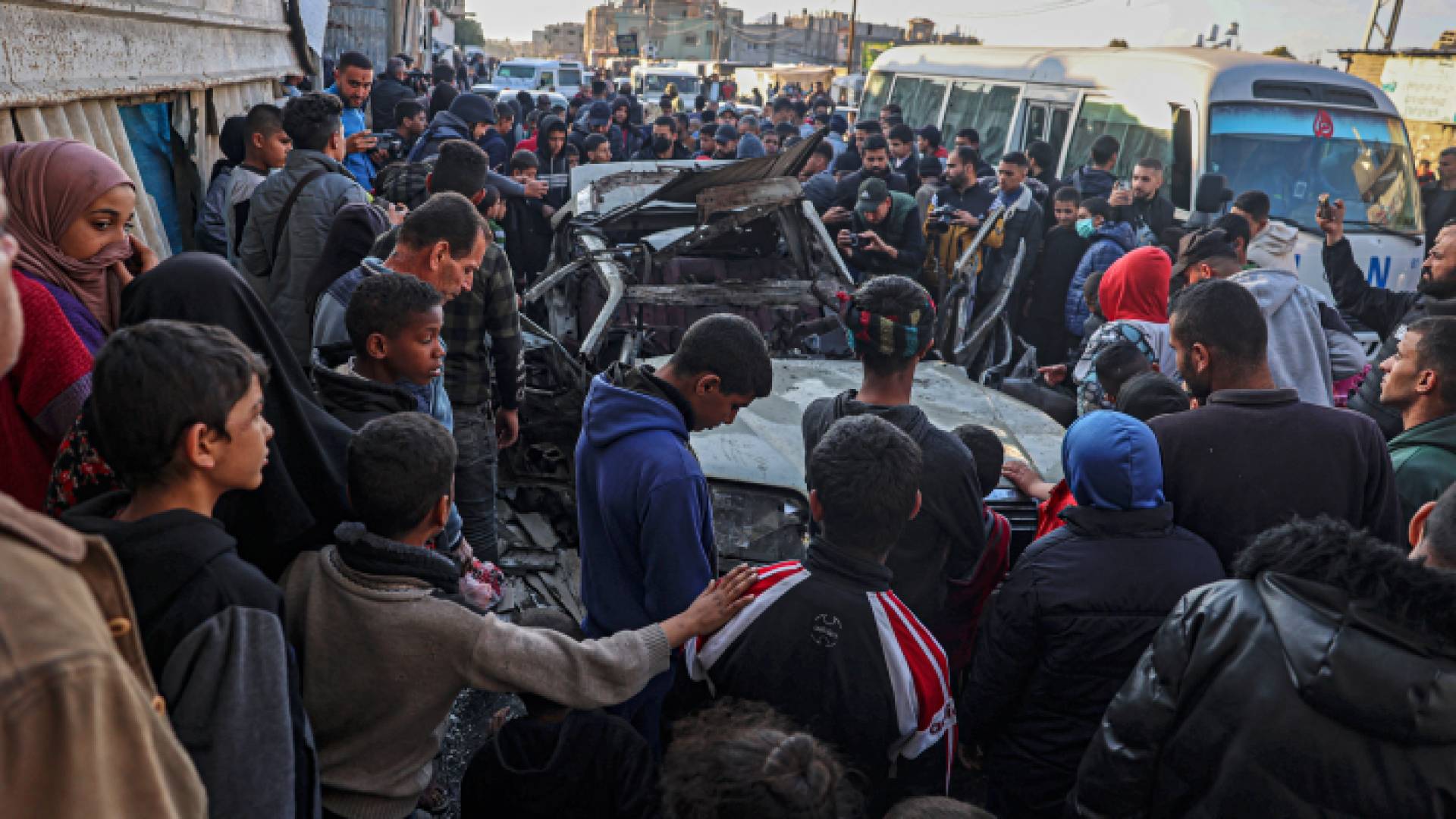 فلسطينيون يقفون عند مركبة استهدفتها طائرات الاحتلال في رفح بقطاع غزة