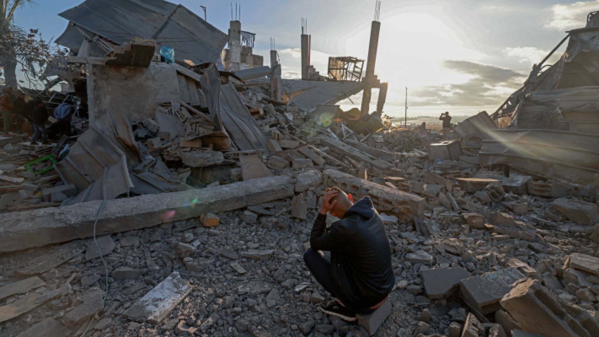 فلسطيني يجلس وسط أنقاض منزل مدمر في أعقاب قصف الاحتلال على رفح - AFP