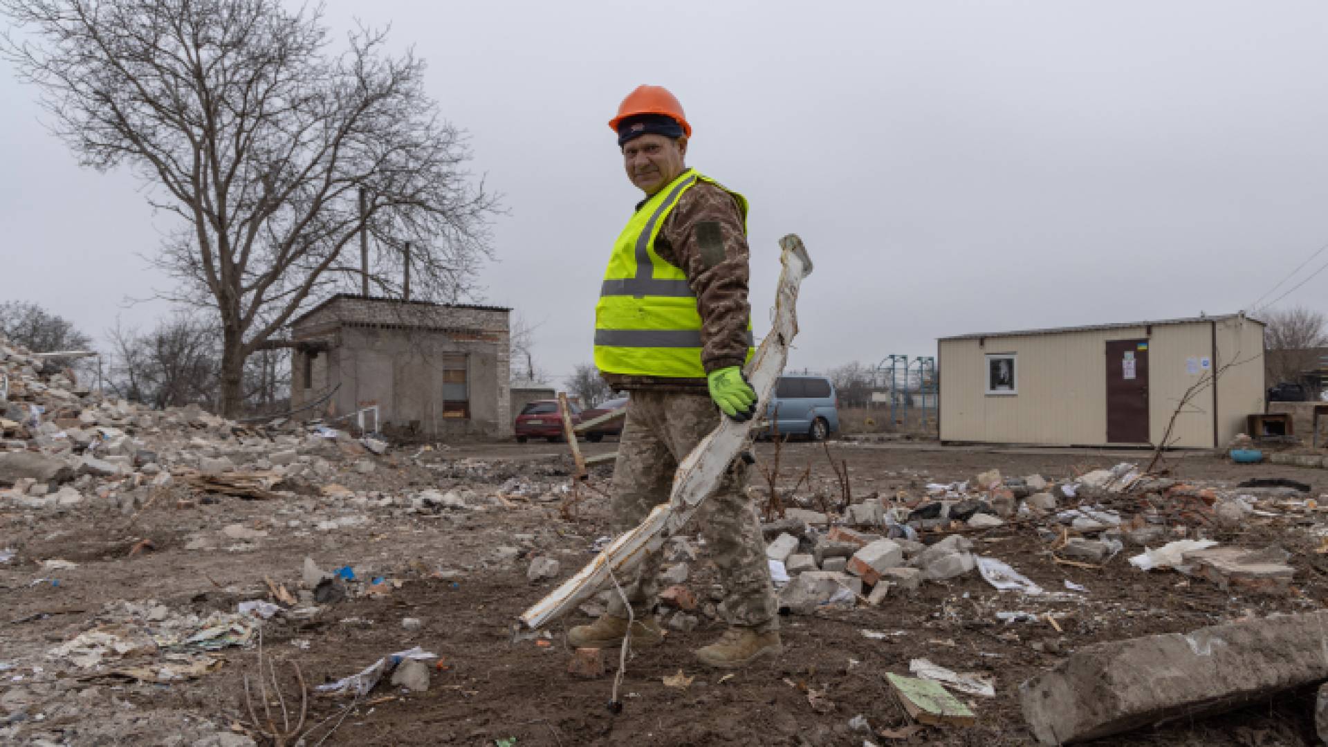 جندي أوكراني سابق يعمل على إزالة أنقاض مدرسة دمرها القصف - AFP