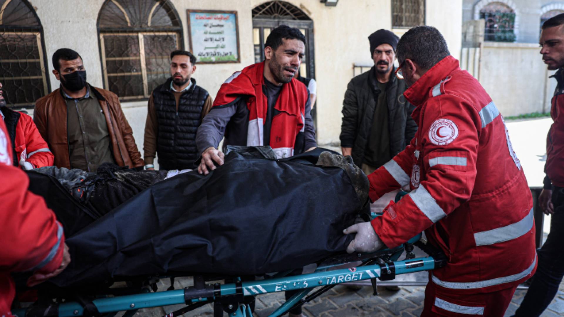 مسعفون ينقلون شهيد إلى مستشفى في أعقاب غارة جوية للاحتلال على مخيم رفح - AFP