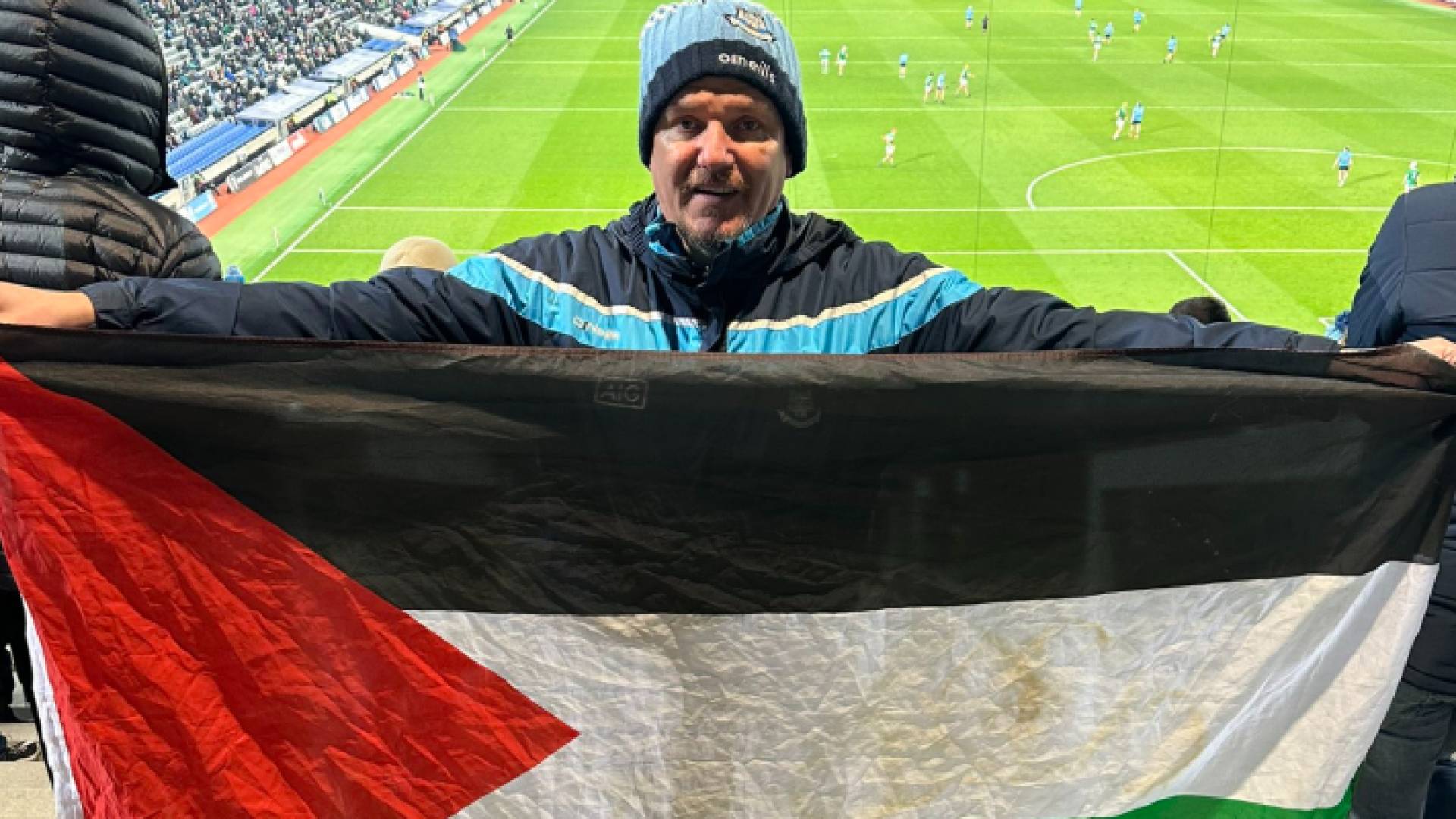 أحد المشجعين يرفع العلم الفلسطيني