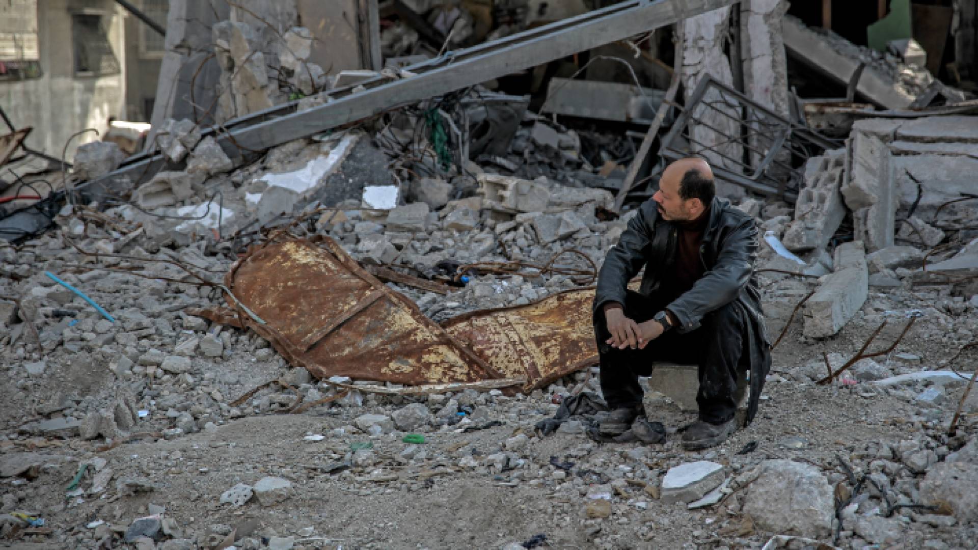 فلسطيني يجلس وسط أنقاض مبنى دمر خلال غارات للاحتلال في مدينة غزة - AFP