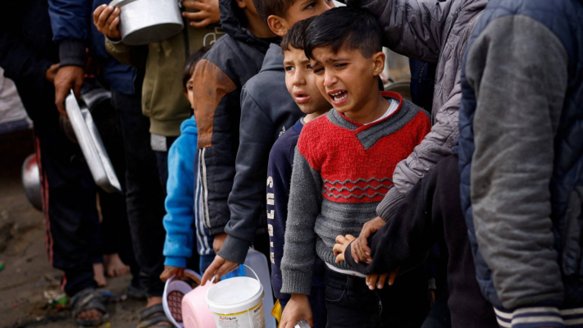 أطفال يصطفون للحصول على مساعدات غذائية